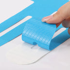 Blue kinesiology tape strips partially peeled on paper backing