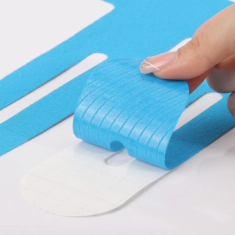 Blue kinesiology tape strips partially peeled on paper backing