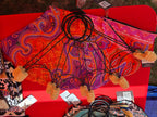 Paisley fan cover with black cord ring stays and orange tassels; product tags included.